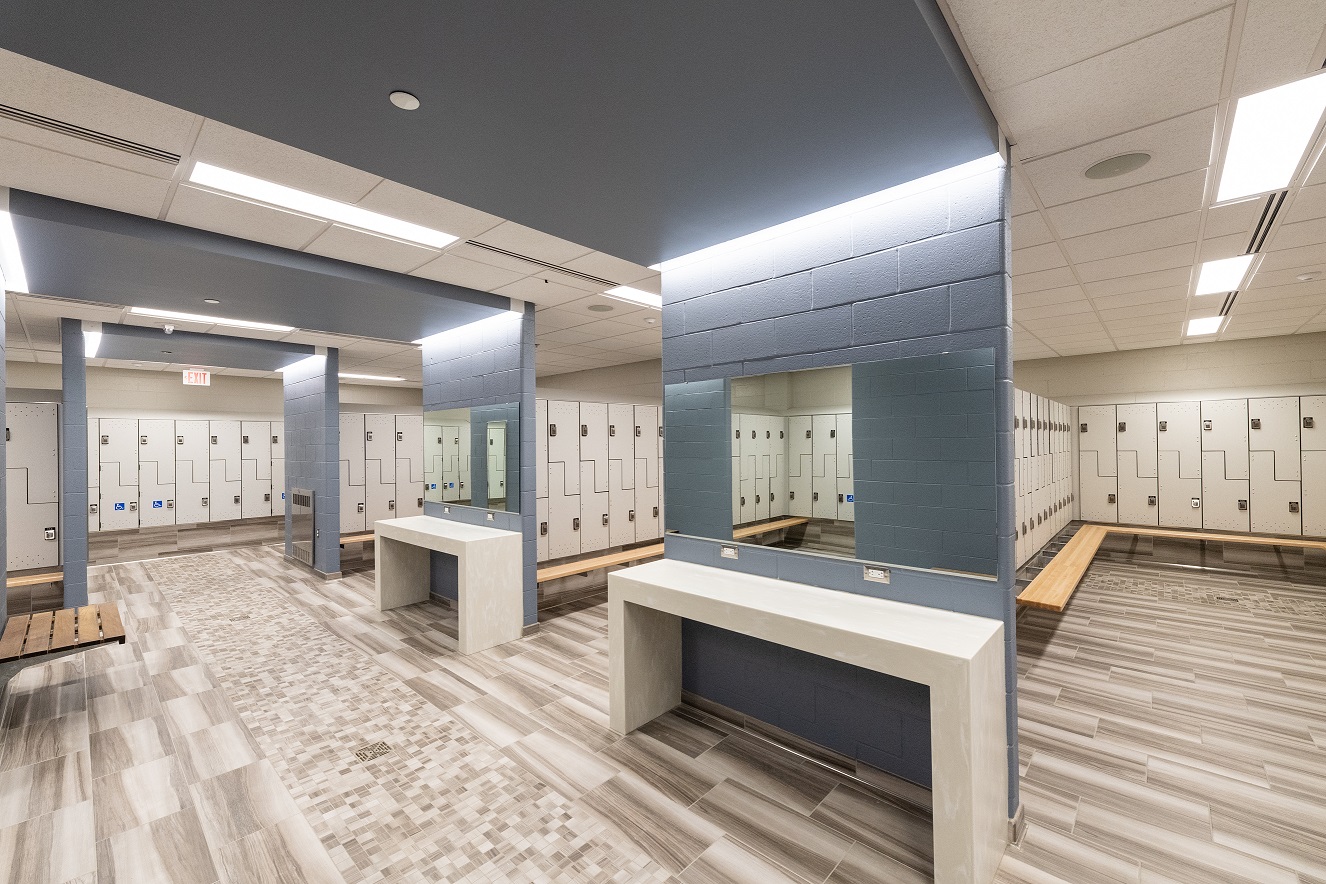 Locker room with benches, mirrors, and tiled floor.